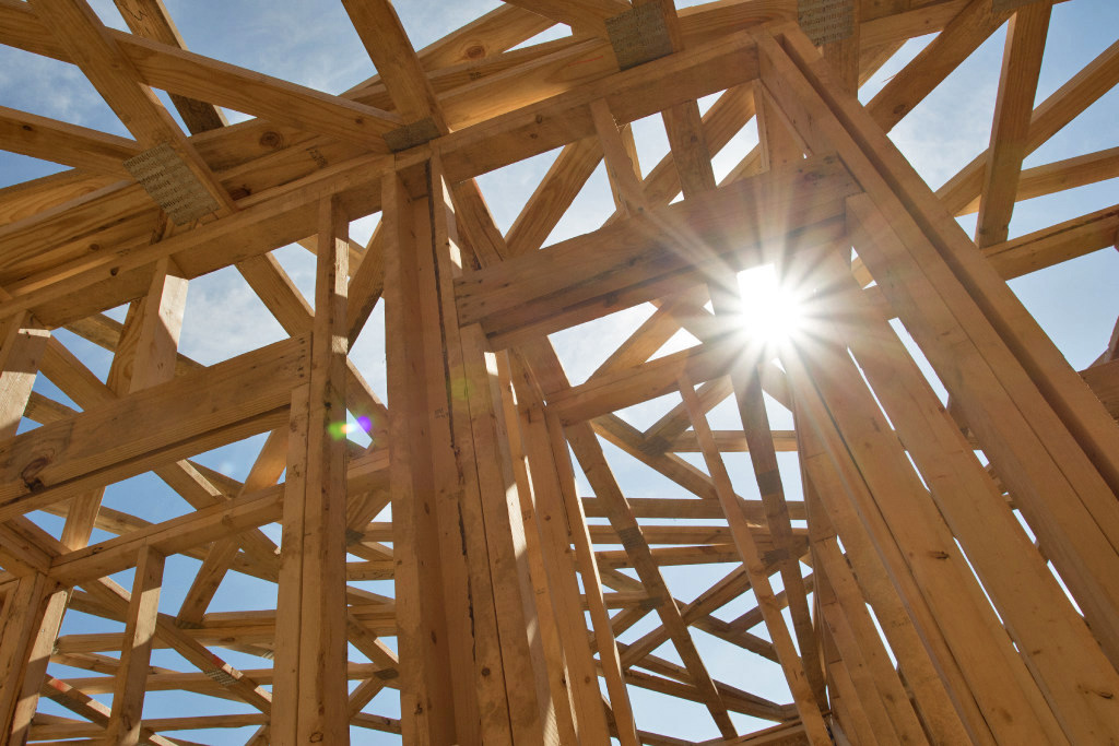 It is a beautiful sunny day at a Green Mountain Habitat for Humanity buildsite as the sun shines through the newly erected framing.