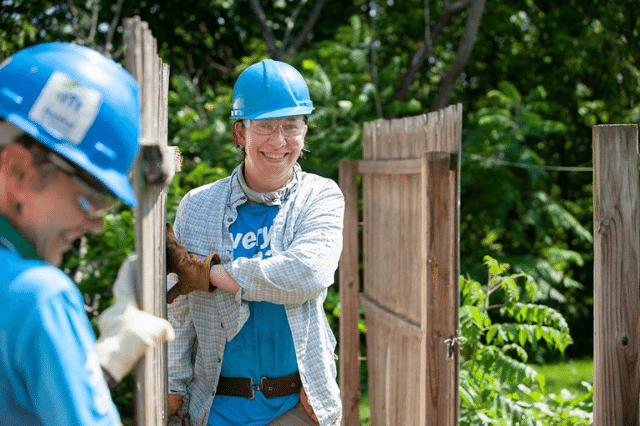 A Habitat volunteer carrying a fence