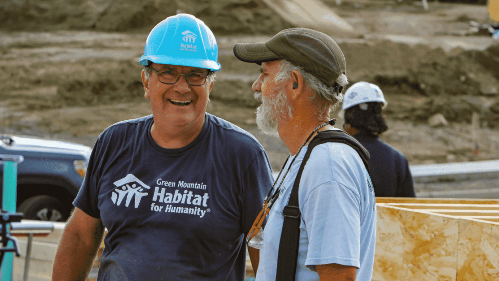 Two Habitat volunteer talking and smiling on-site