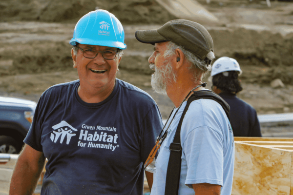 Two Habitat volunteer talking and smiling on-site